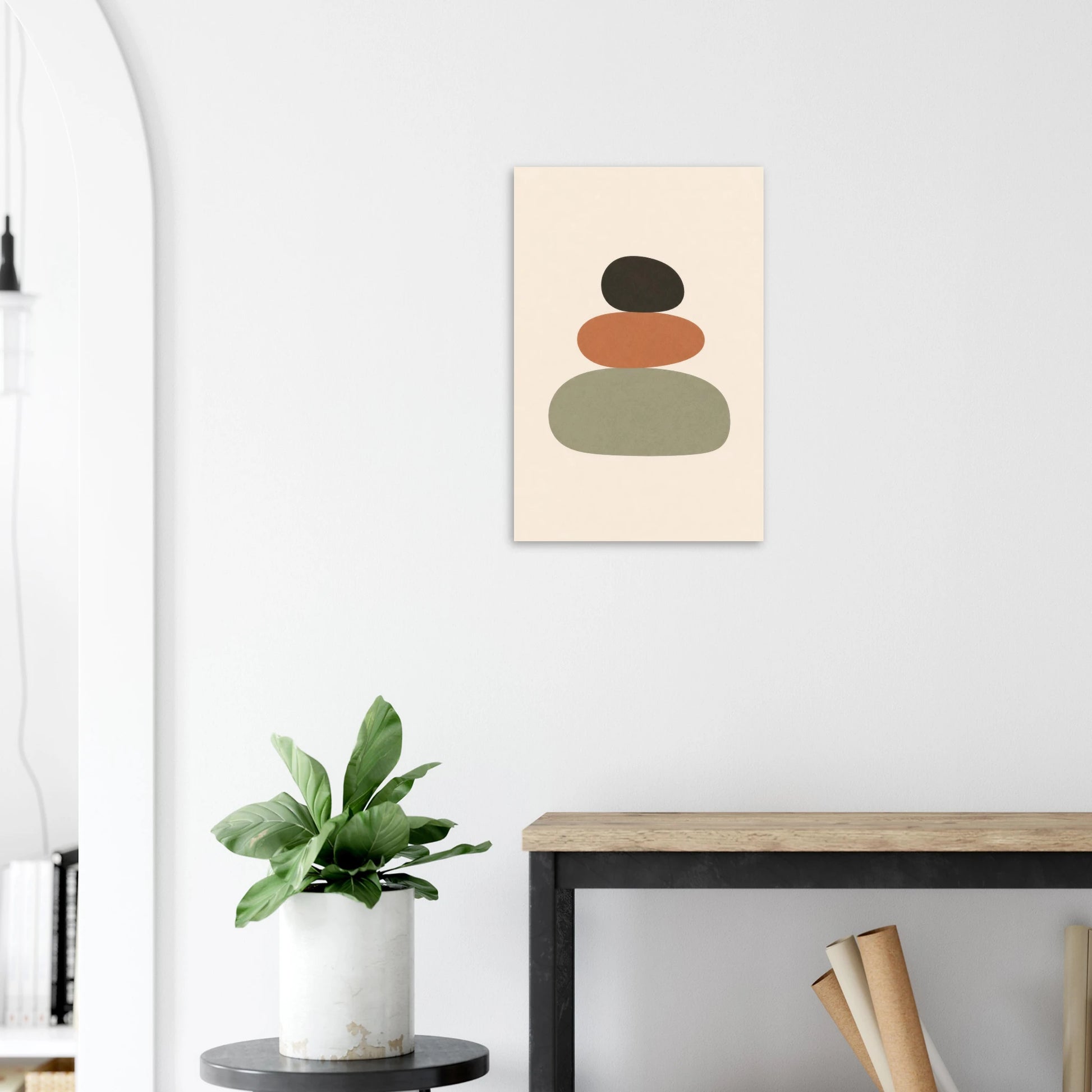 Balanced Stones nursery print on a white wall above a wooden bench with a plant