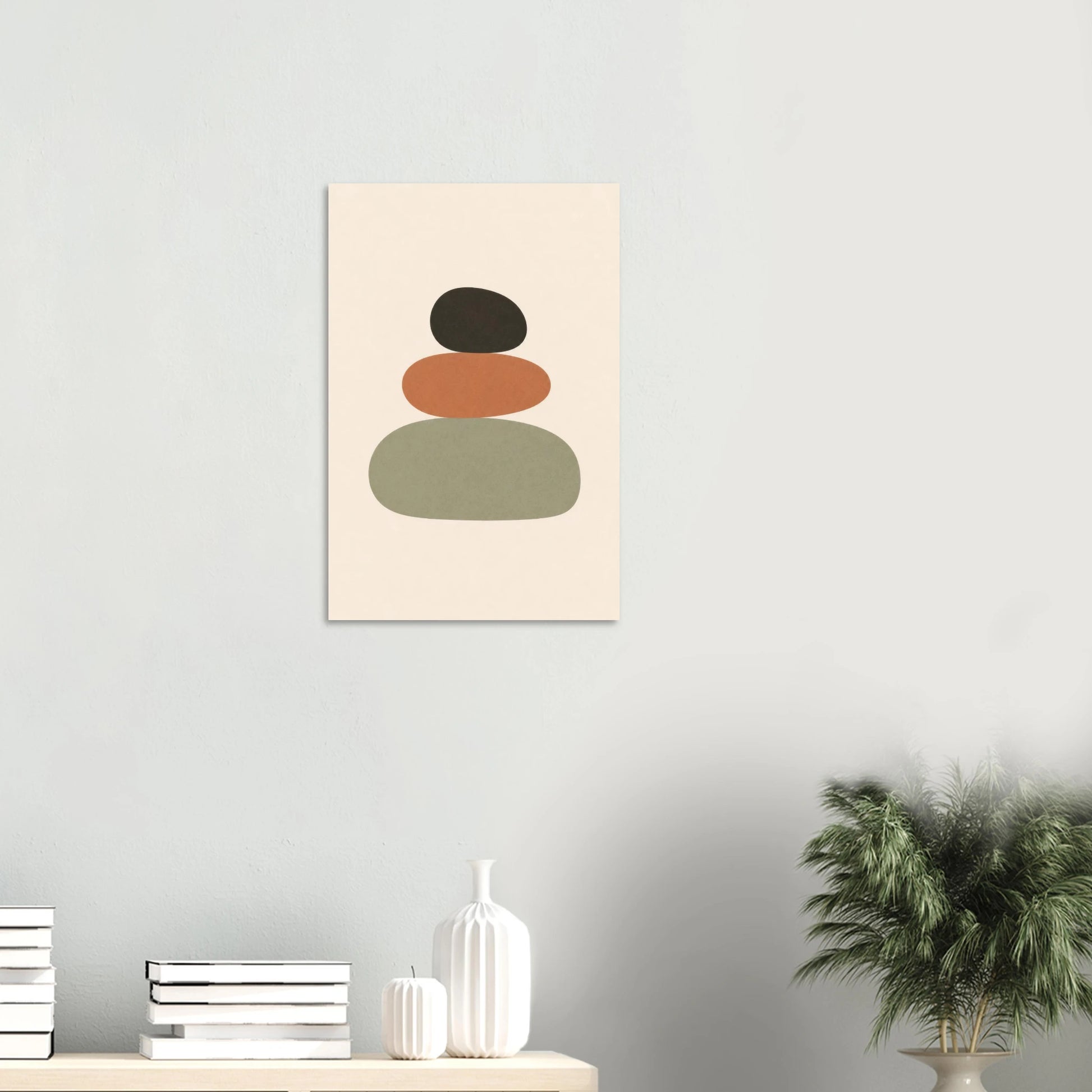 Balanced Stones nursery print on a white wall above a shelf with books and vases