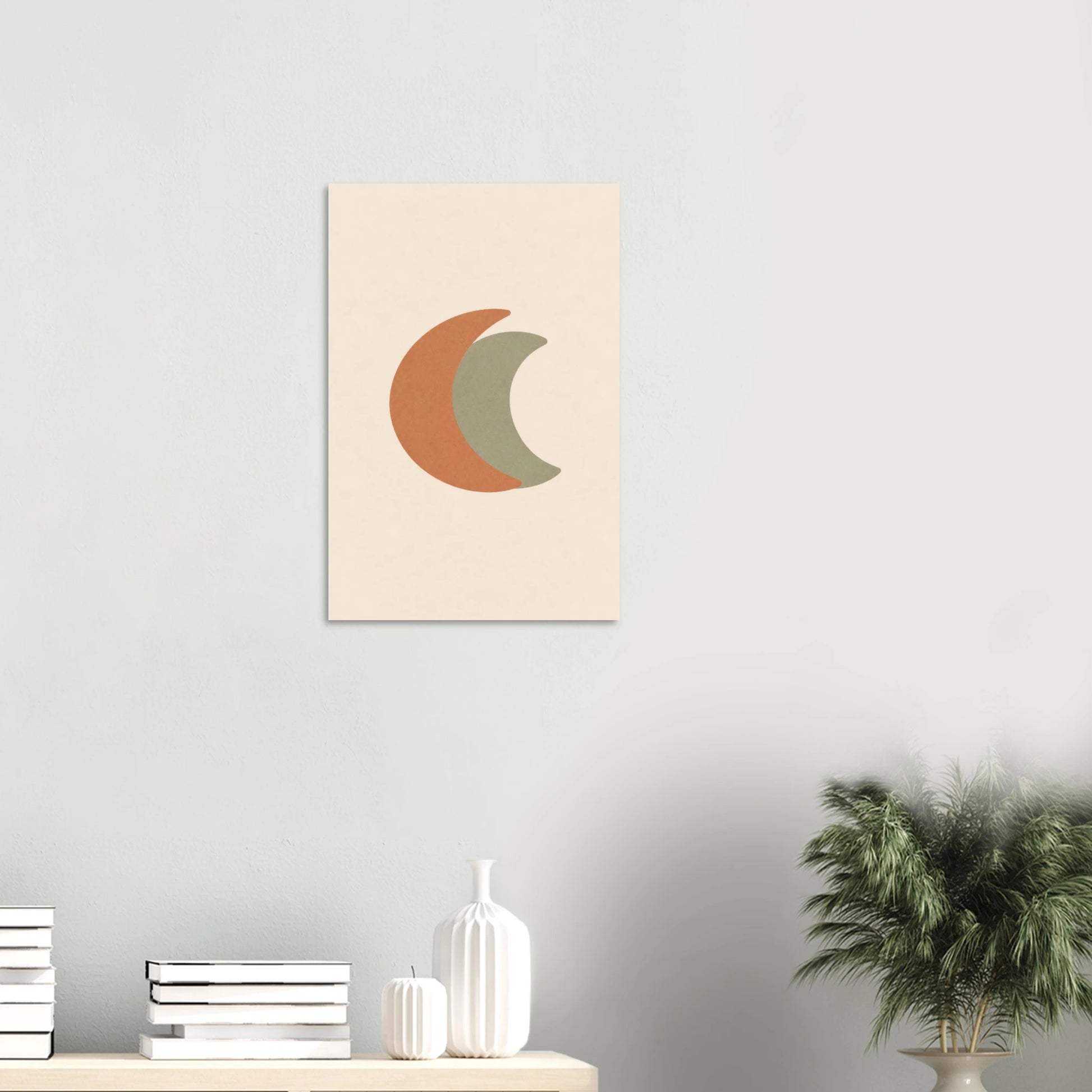 Crescent Moon nursery print on a white wall above a shelf with books and vases