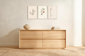 Three framed botanical line-art nursery prints hung in a row above a light oak dresser